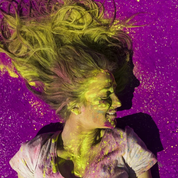 elevated-view-smiling-woman-covered-with-holi-color-powder-scaled